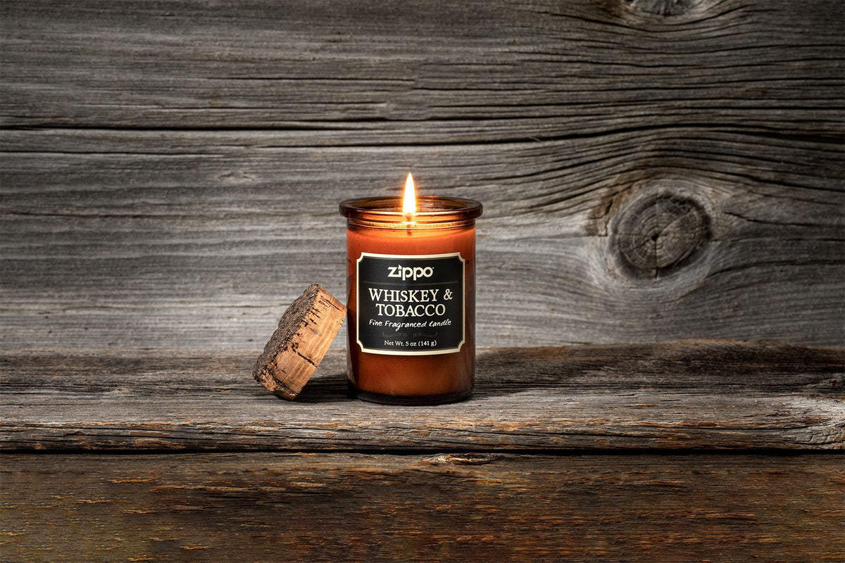 Świeca Zippo Whiskey and Tobacco brązowa z korkową pokrywką z płomieniem na tle drewna