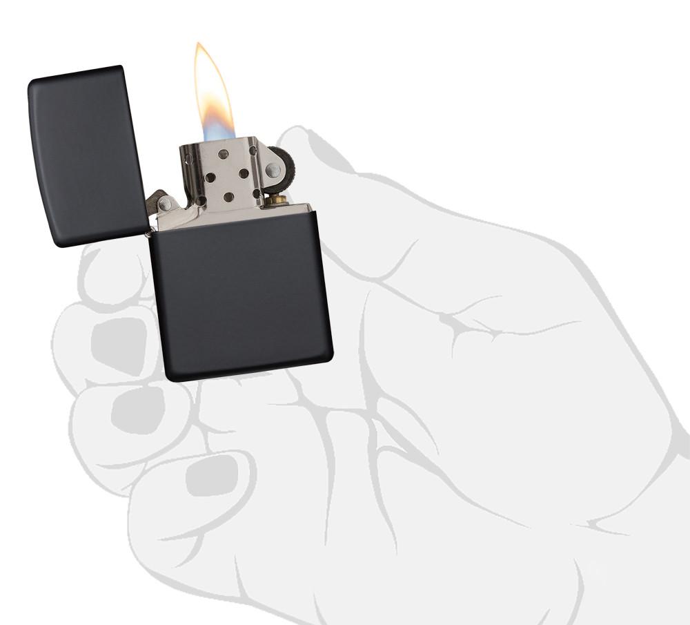Widok z przodu zapalniczka Zippo Black Matte model podstawowy otwarta z płomieniem w stylizowanej dłoni